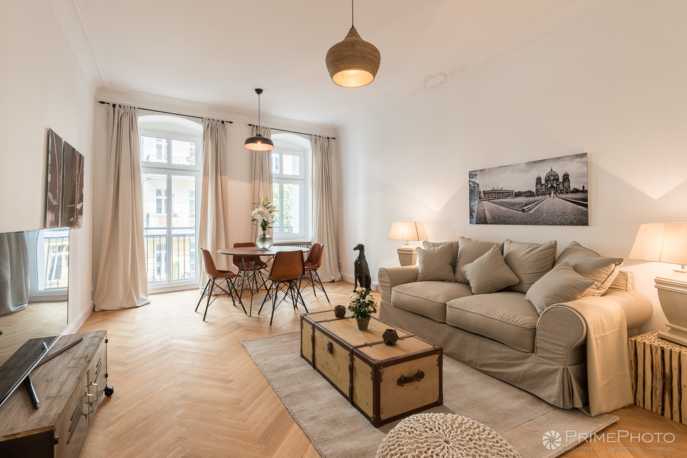 Idee per un soggiorno tropicale di medie dimensioni con pavimento in legno massello medio, pavimento marrone e pareti bianche