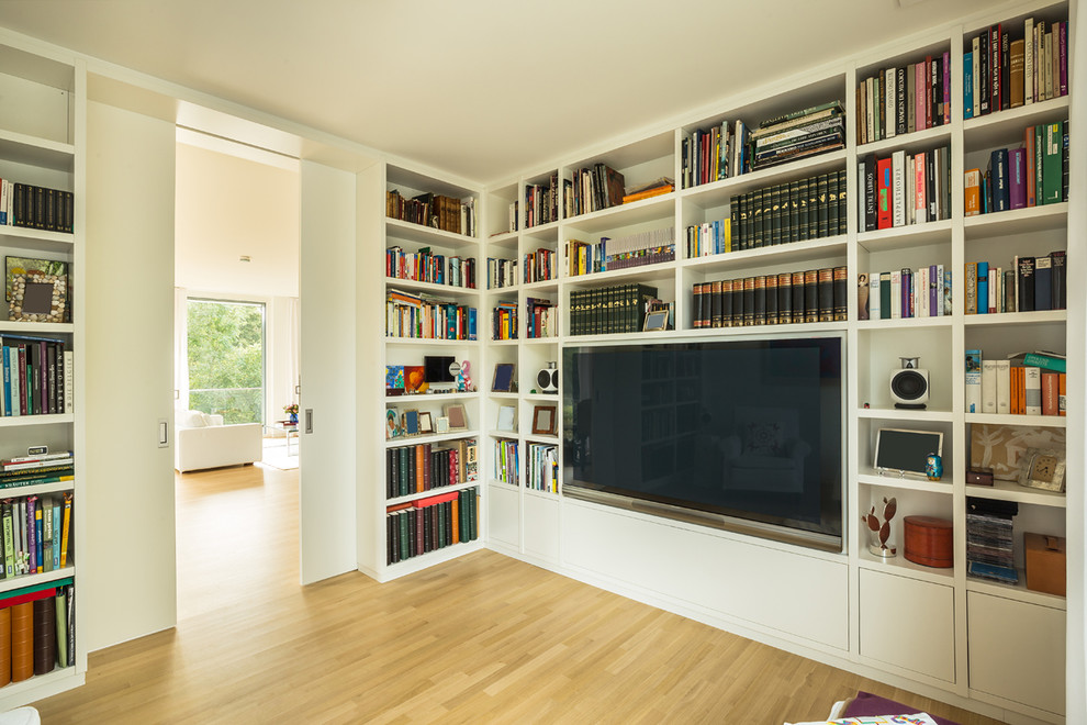 Идея дизайна: гостиная комната в современном стиле с с книжными шкафами и полками и телевизором на стене