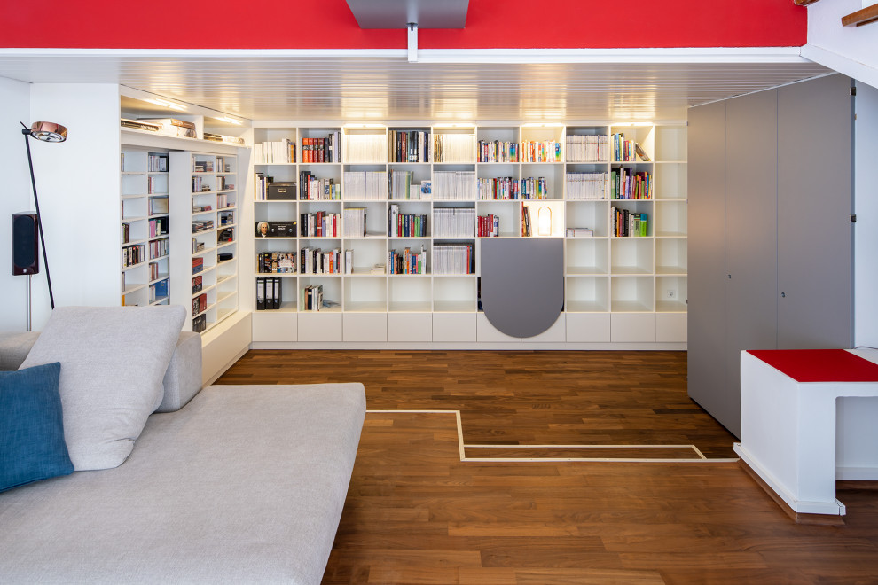 Offene Moderne Bibliothek mit weißer Wandfarbe, braunem Holzboden und braunem Boden in Sonstige