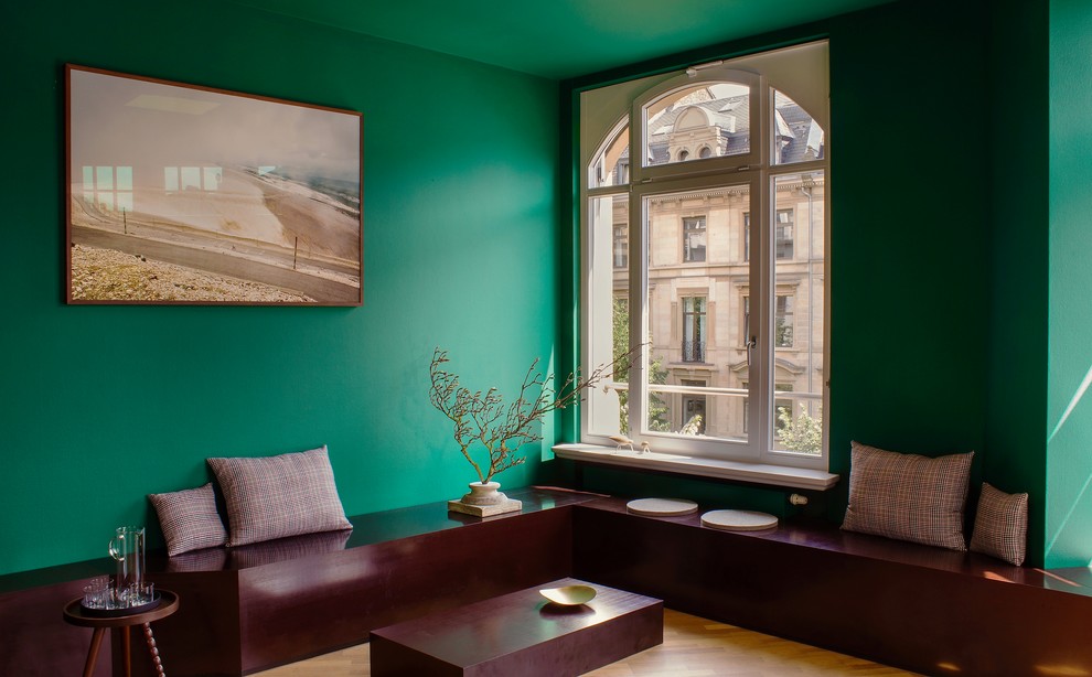 Mittelgroßes Modernes Wohnzimmer mit grüner Wandfarbe, braunem Holzboden und braunem Boden in Frankfurt am Main