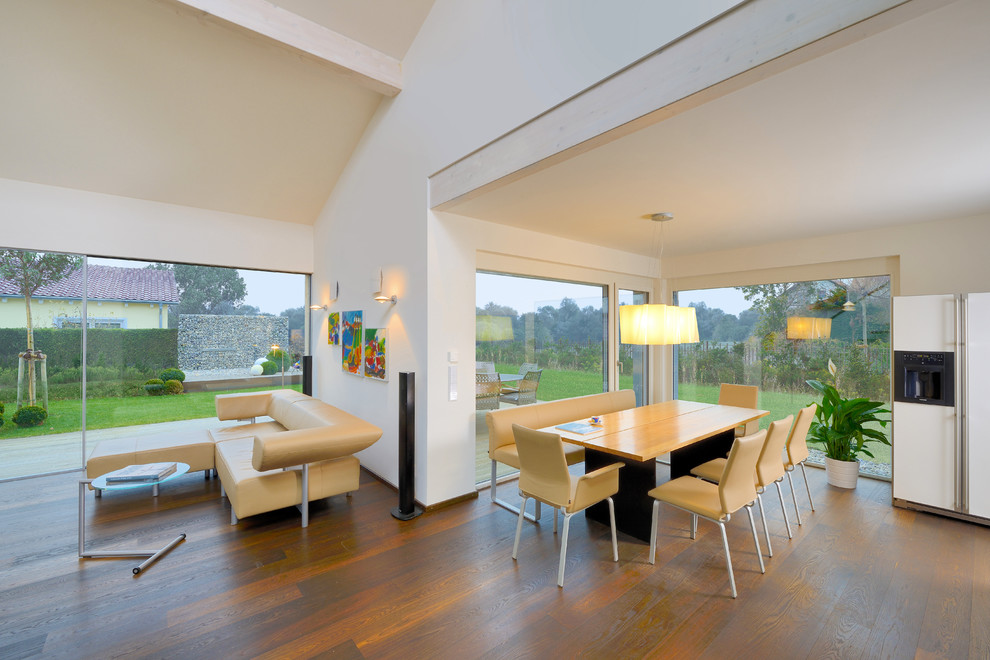 Esempio di un soggiorno minimal di medie dimensioni e aperto con pareti bianche, pavimento in legno massello medio e pavimento marrone