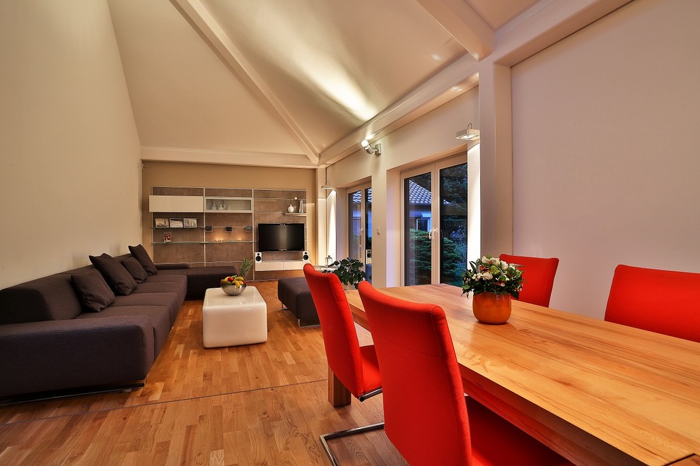 Großes, Repräsentatives, Offenes Modernes Wohnzimmer mit weißer Wandfarbe, braunem Holzboden, TV-Wand und braunem Boden in Berlin