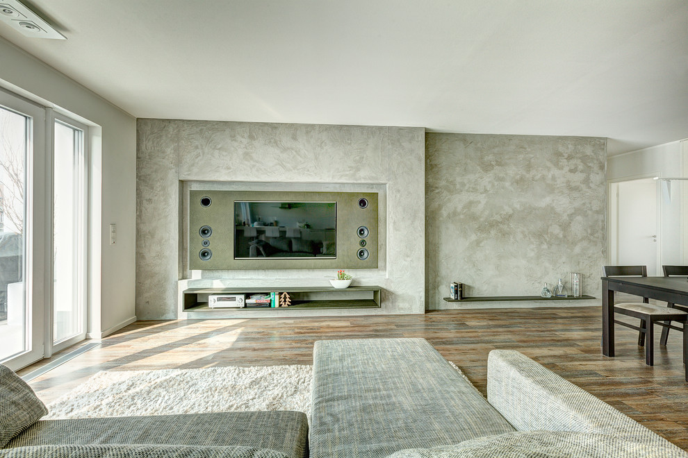 Ejemplo de salón abierto contemporáneo grande con paredes grises y pared multimedia