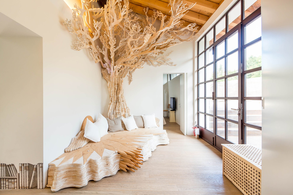 Esempio di un soggiorno eclettico di medie dimensioni e aperto con pareti bianche, parquet chiaro, TV a parete e pavimento beige