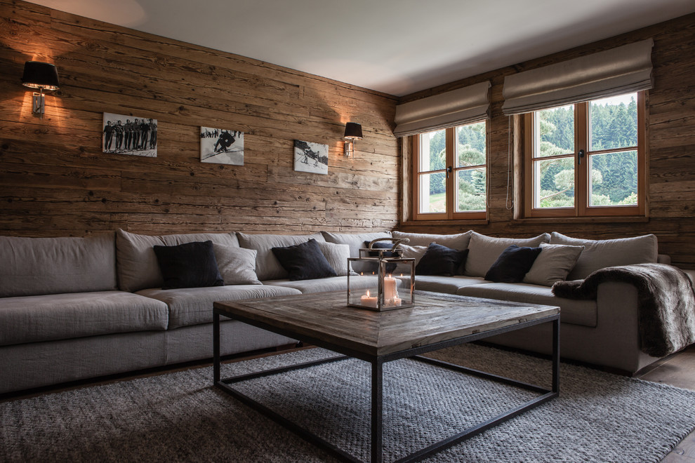 Mittelgroßes, Abgetrenntes Rustikales Wohnzimmer ohne Kamin mit brauner Wandfarbe, gebeiztem Holzboden und braunem Boden in München