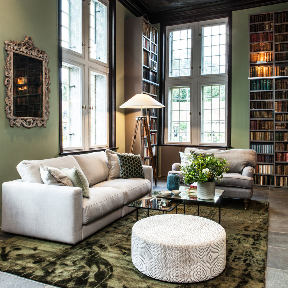 Huge trendy enclosed concrete floor family room library photo in Hamburg with green walls, a standard fireplace, a plaster fireplace and no tv