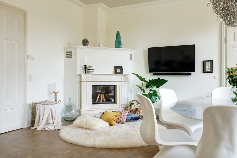Mittelgroßes, Abgetrenntes Modernes Wohnzimmer mit weißer Wandfarbe, braunem Holzboden, Kamin, Kaminumrandung aus Stein, TV-Wand und braunem Boden in Berlin