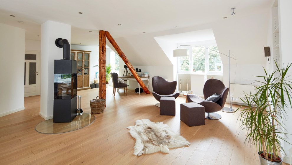Immagine di un soggiorno scandinavo aperto e di medie dimensioni con sala formale, pareti bianche, parquet chiaro, pavimento beige, stufa a legna e nessuna TV