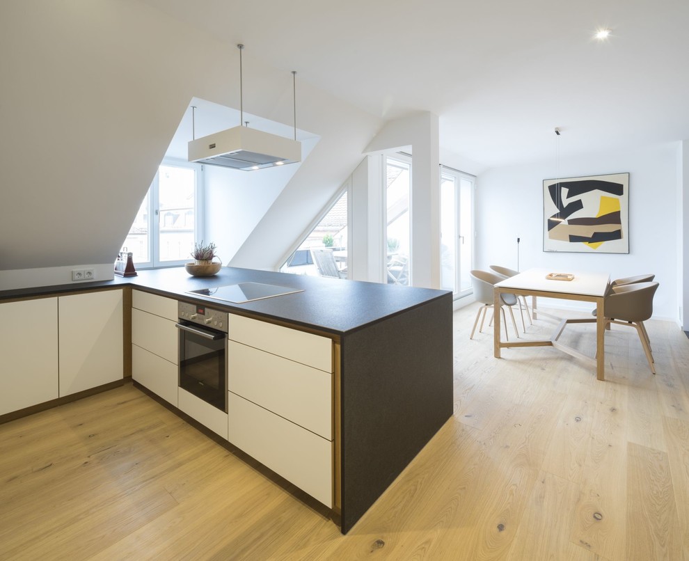 Modernes Wohnzimmer ohne Kamin mit weißer Wandfarbe und hellem Holzboden in München