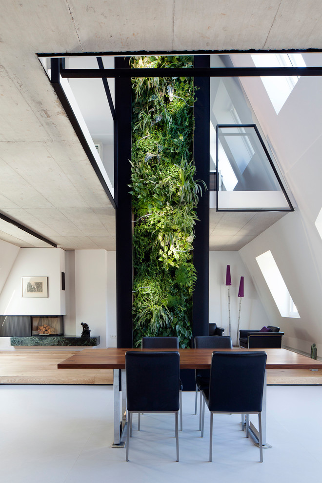 Esempio di una sala da pranzo minimalista con pareti bianche, camino ad angolo e pavimento grigio