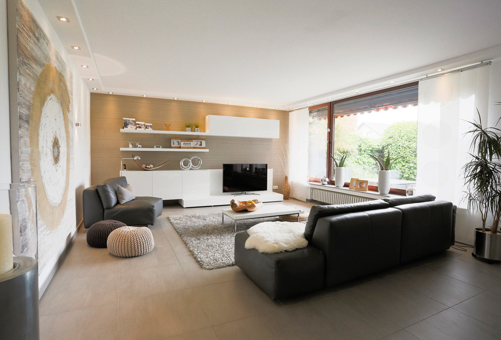 Offenes, Großes Modernes Wohnzimmer mit weißer Wandfarbe, Multimediawand, Keramikboden und grauem Boden in Düsseldorf