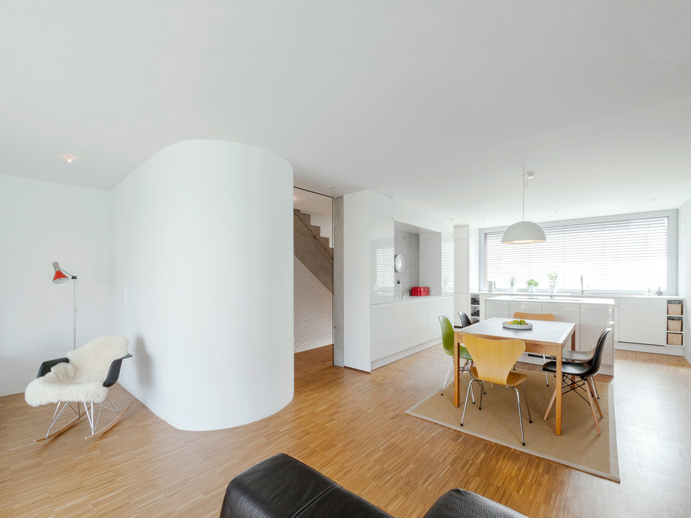 Idées déco pour un salon contemporain de taille moyenne et ouvert avec un mur blanc, un sol en bois brun et un sol marron.