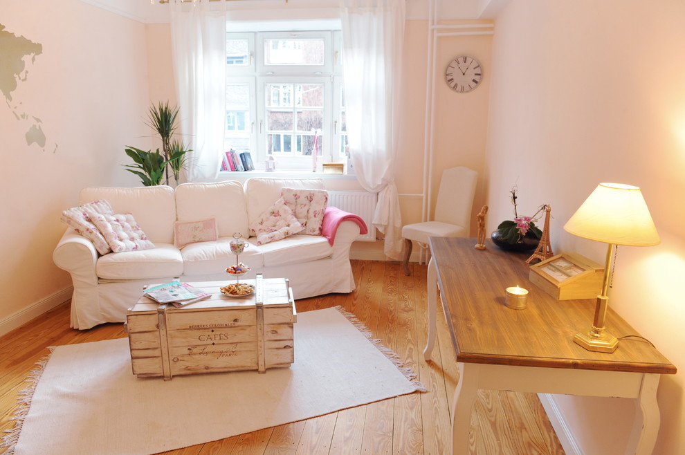 На фото: изолированная гостиная комната среднего размера в стиле шебби-шик с розовыми стенами, светлым паркетным полом, коричневым полом, с книжными шкафами и полками и скрытым телевизором без камина с