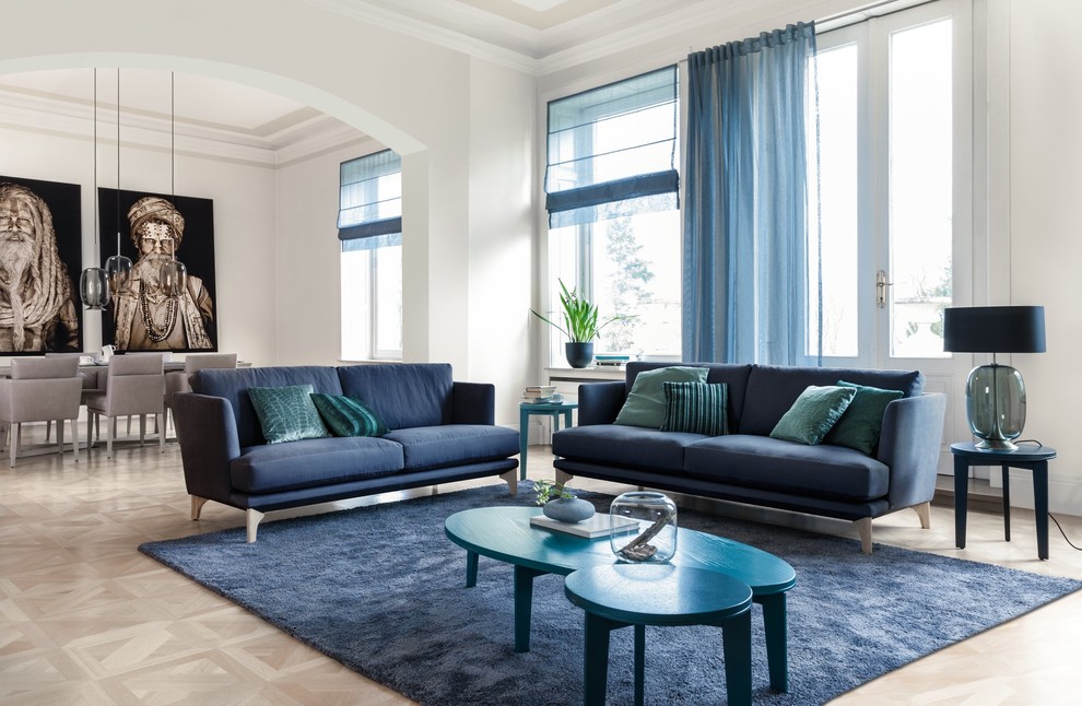 Imagen de sala de estar abierta contemporánea grande sin chimenea y televisor con paredes blancas, suelo de madera en tonos medios, suelo beige y alfombra