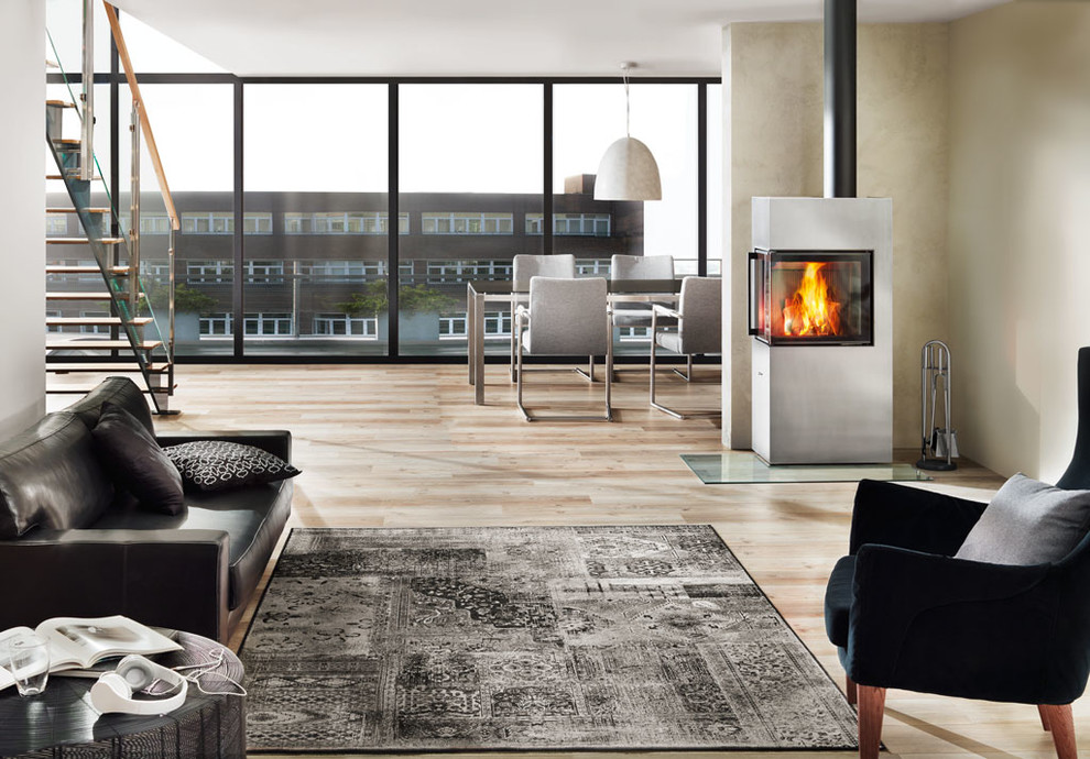 Пример оригинального дизайна: гостиная комната в стиле модернизм с печью-буржуйкой и фасадом камина из металла