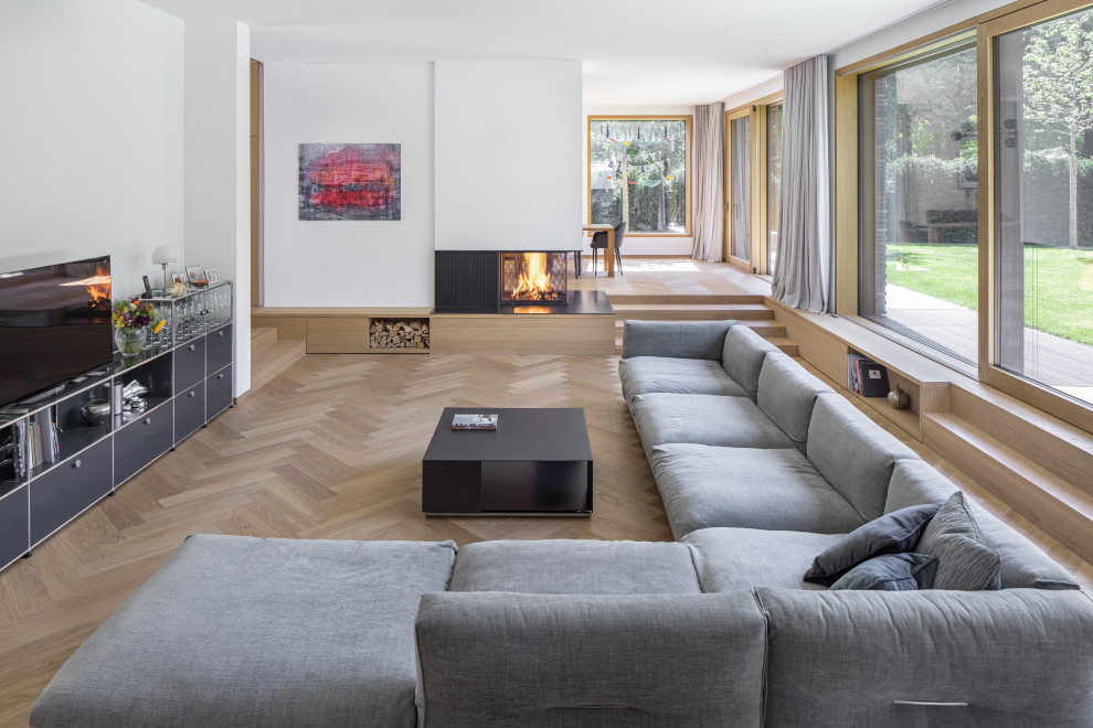 Inspiration pour une très grande salle de séjour design ouverte avec un mur blanc, un sol en bois brun, un poêle à bois et un sol marron.