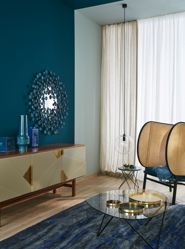 Esempio di un soggiorno minimalista con pareti blu, pavimento in legno massello medio e nessun camino