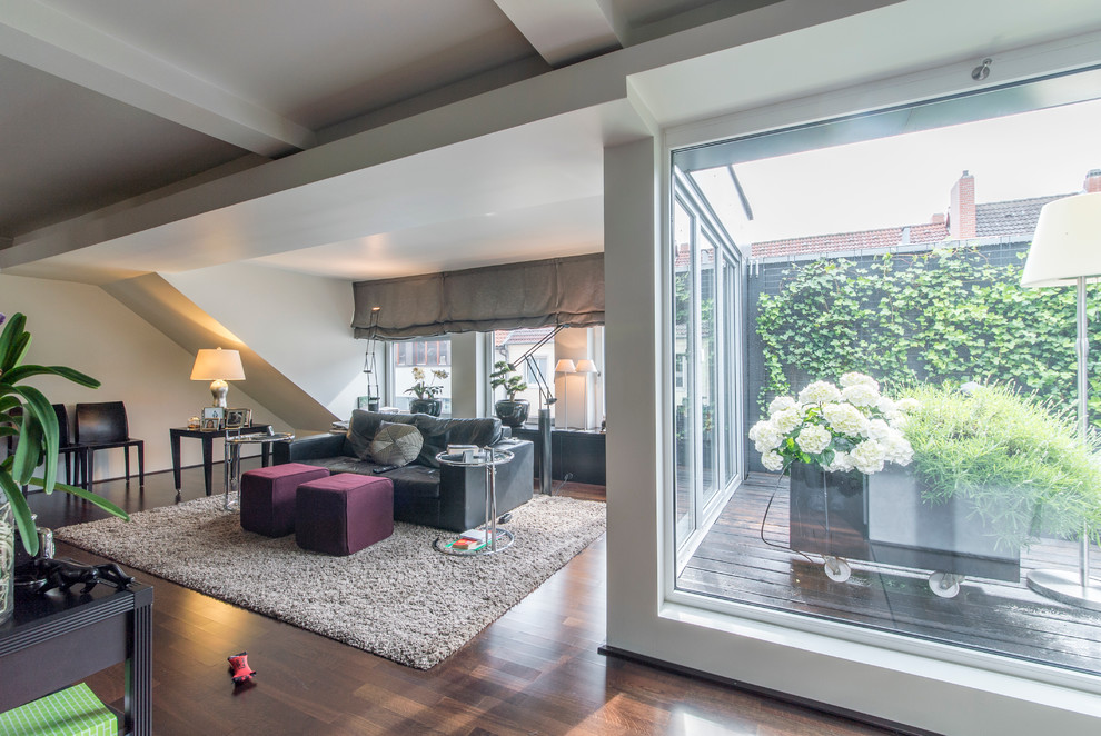 Geräumiges, Offenes Klassisches Wohnzimmer ohne Kamin mit weißer Wandfarbe, braunem Holzboden, TV-Wand und braunem Boden in Hannover