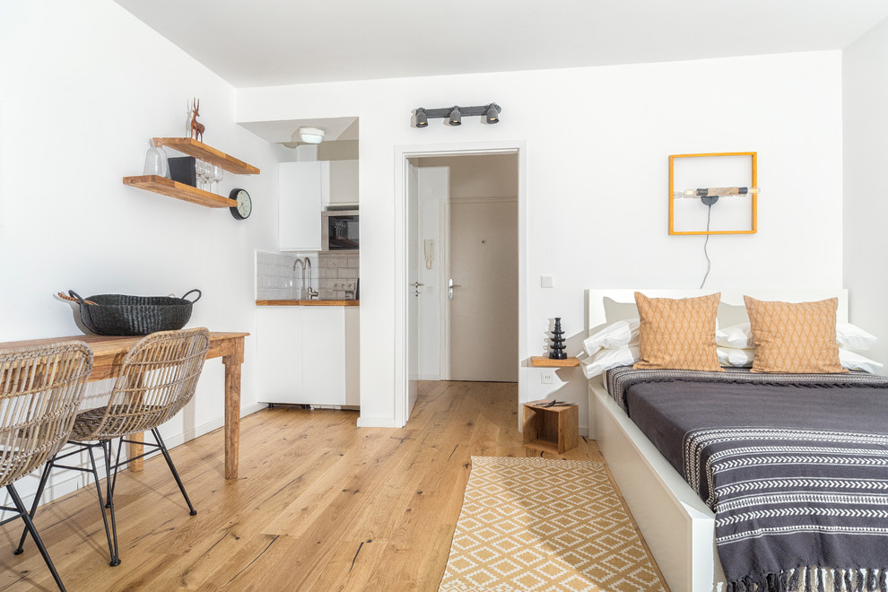 Mittelgroßes, Fernseherloses, Abgetrenntes Modernes Wohnzimmer ohne Kamin mit weißer Wandfarbe, braunem Holzboden und braunem Boden in Düsseldorf