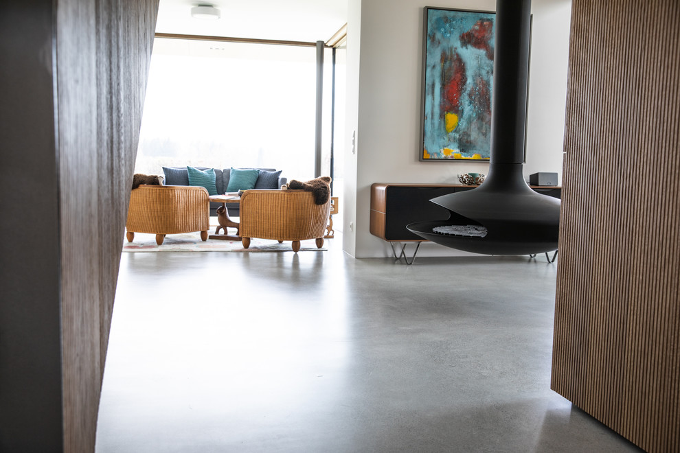 На фото: гостиная комната в современном стиле с бетонным полом с