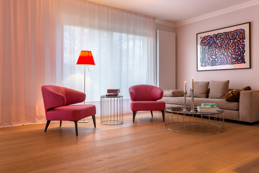 Imagen de sala de estar abierta actual de tamaño medio sin chimenea y televisor con suelo de madera clara y suelo beige