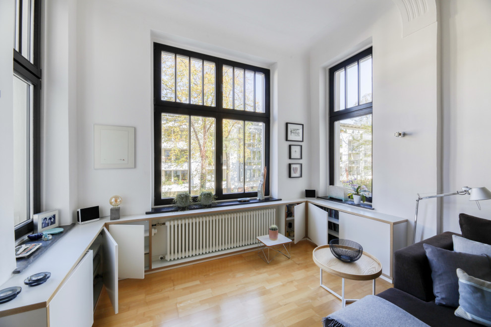 Foto di un ampio soggiorno design aperto con pareti bianche, parquet chiaro, TV autoportante, pavimento marrone e soffitto a volta