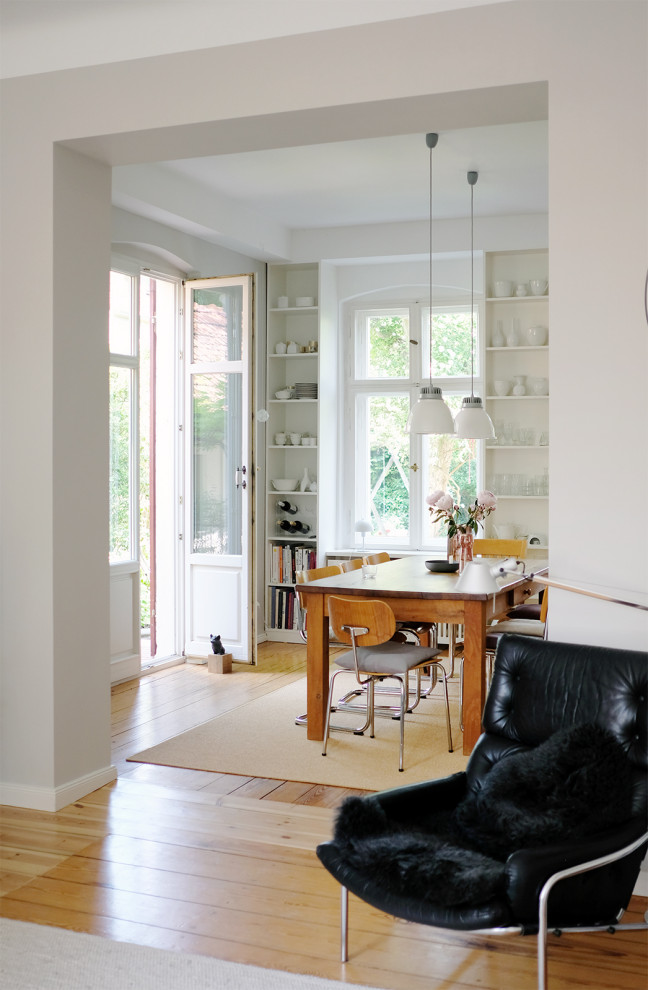Offenes Modernes Wohnzimmer mit grauer Wandfarbe, hellem Holzboden und Kaminofen in Berlin