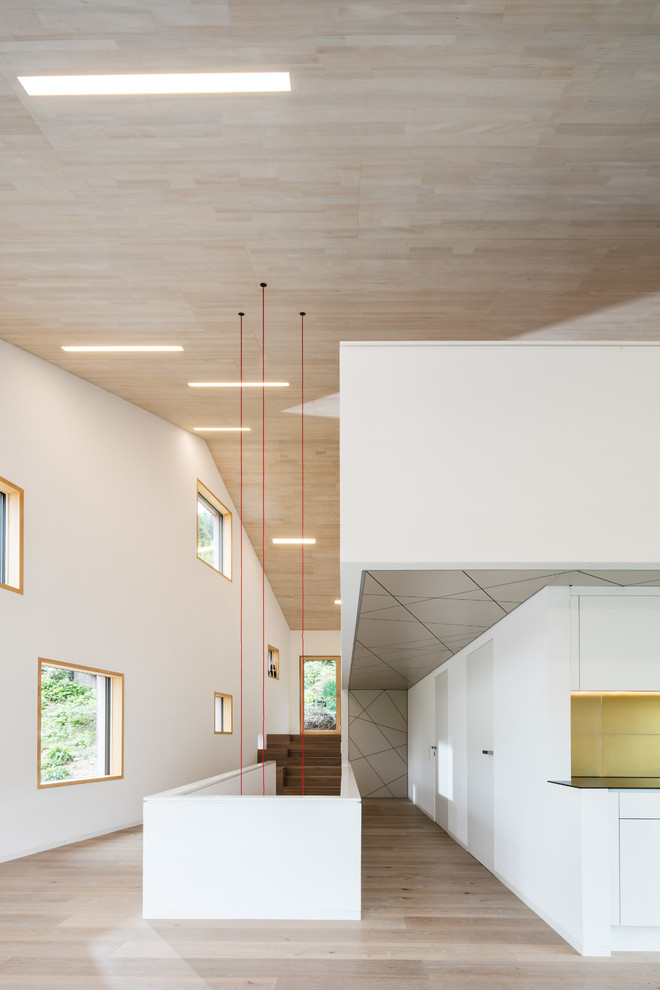 Foto di un grande soggiorno minimalista aperto con pareti bianche, pavimento in legno massello medio e pavimento marrone