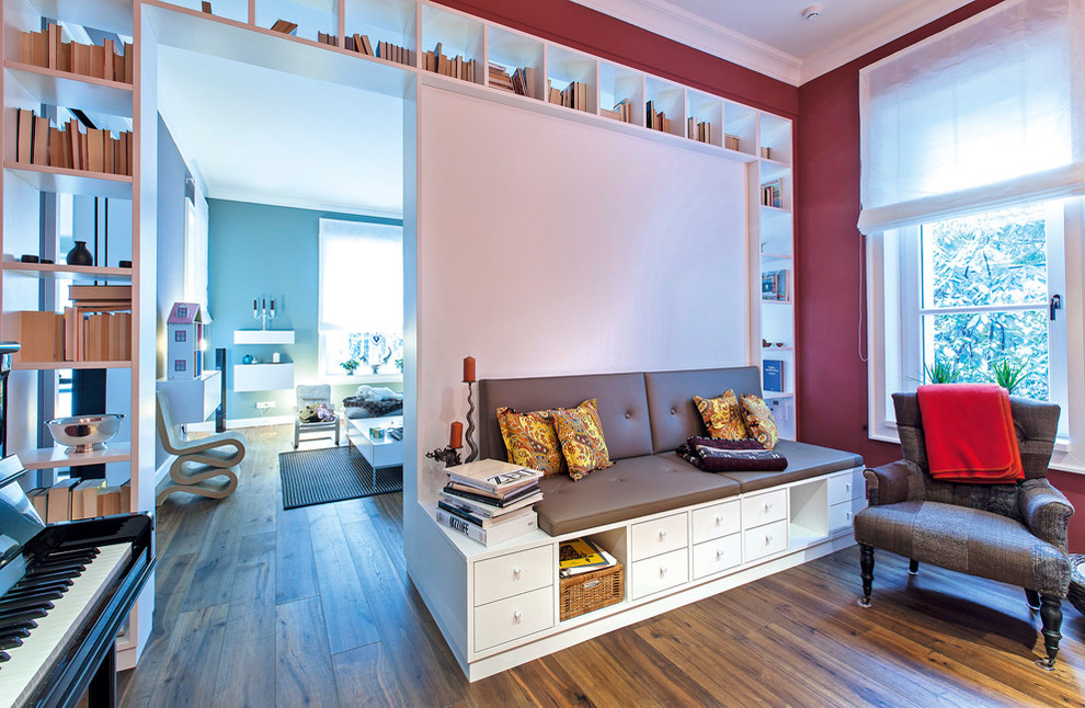Esempio di un soggiorno eclettico di medie dimensioni e chiuso con sala della musica, pareti rosse e pavimento in legno massello medio