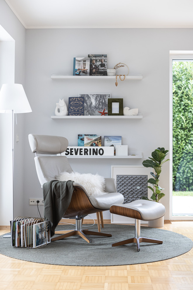 Imagen de sala de estar con biblioteca contemporánea con paredes grises