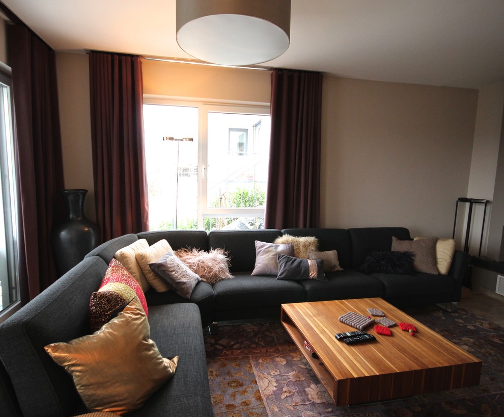 Foto de salón para visitas abierto bohemio grande sin chimenea con paredes beige, suelo de madera oscura, televisor independiente y suelo marrón