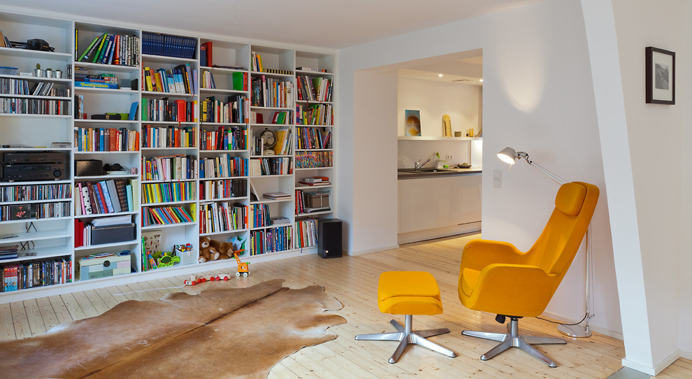 Идея дизайна: открытая гостиная комната среднего размера в современном стиле с с книжными шкафами и полками, белыми стенами, светлым паркетным полом и ковром на полу без камина, телевизора