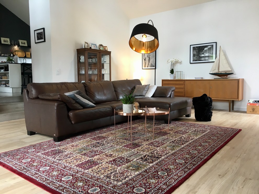 Cette photo montre une salle de séjour tendance de taille moyenne et ouverte avec un bar de salon, un mur blanc, un téléviseur fixé au mur, parquet clair et un sol beige.