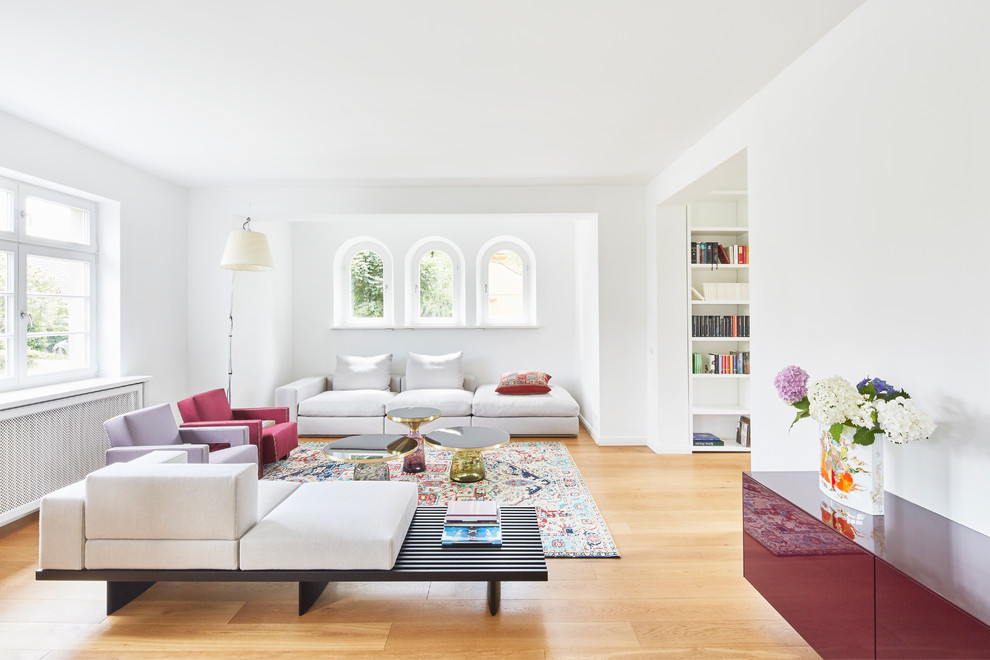 Mittelgroßes, Repräsentatives, Fernseherloses, Offenes Modernes Wohnzimmer ohne Kamin mit weißer Wandfarbe, braunem Holzboden und braunem Boden in Köln