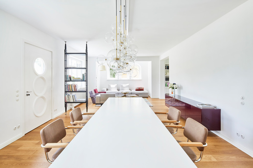 Esempio di una grande sala da pranzo minimal con pareti bianche, pavimento in legno massello medio e nessun camino