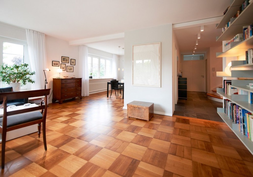 Foto di un grande soggiorno contemporaneo aperto con pavimento in legno massello medio, nessun camino e pareti bianche