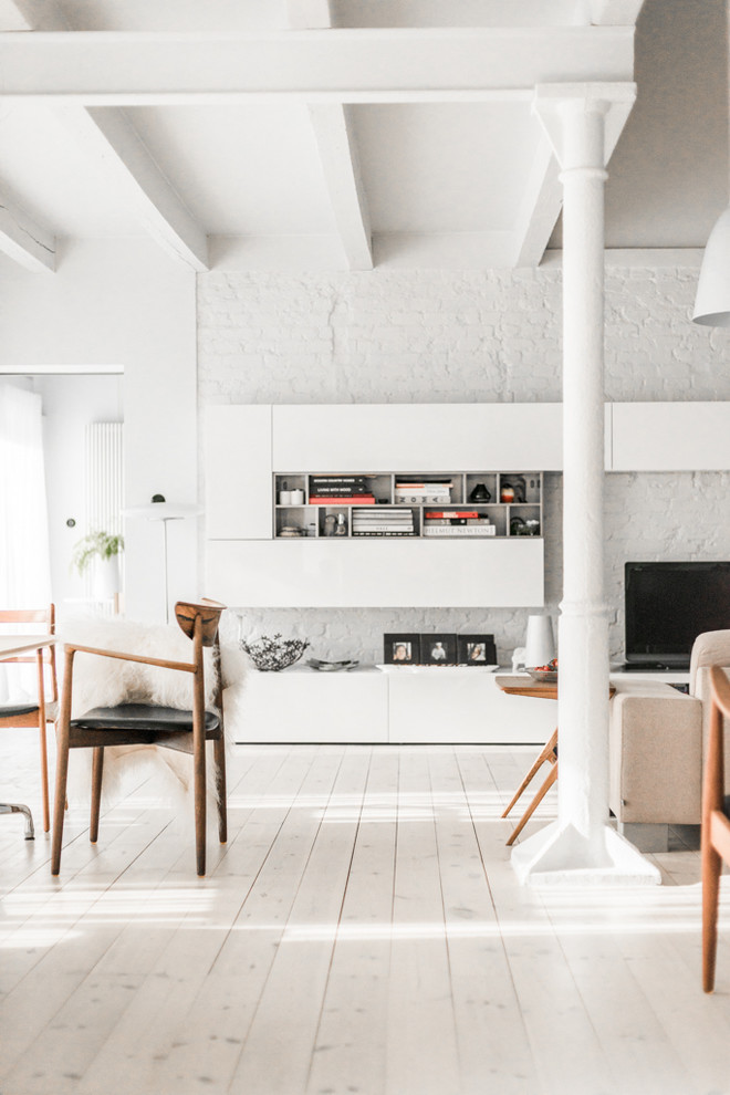 Idee per un grande soggiorno scandinavo aperto con libreria, pareti bianche e parquet chiaro
