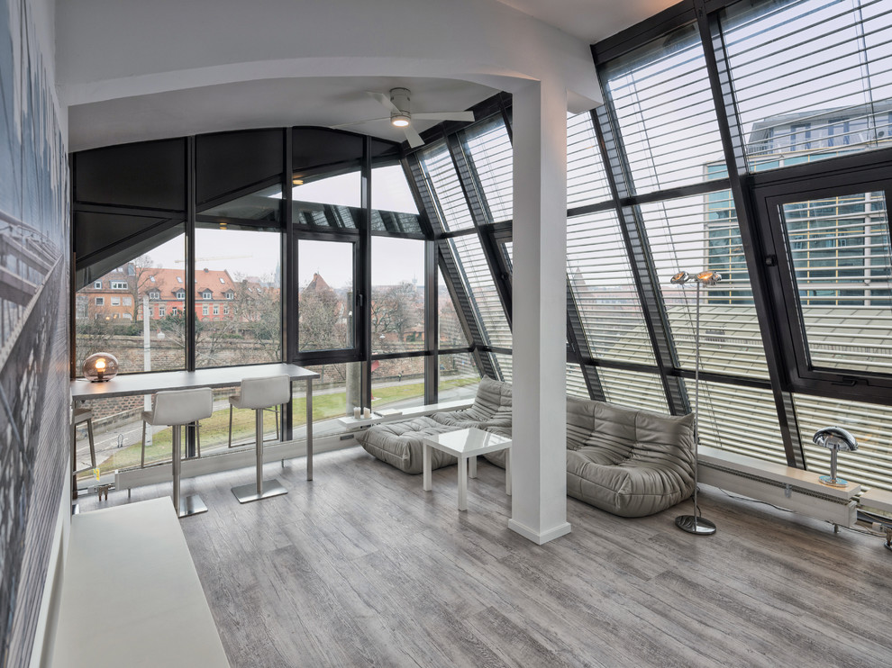 Mittelgroßes, Fernseherloses, Offenes Modernes Wohnzimmer ohne Kamin mit hellem Holzboden und grauem Boden in Nürnberg