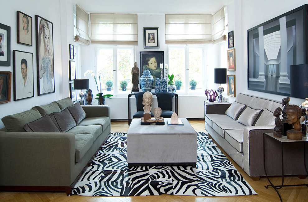 Imagen de sala de estar cerrada bohemia de tamaño medio sin chimenea con paredes blancas y suelo de madera clara