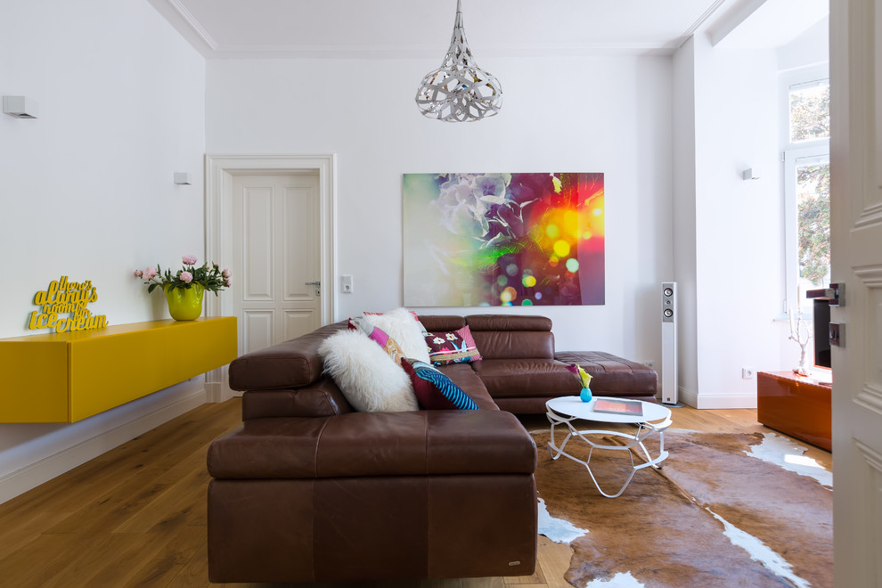 Großes, Abgetrenntes Eklektisches Wohnzimmer ohne Kamin mit weißer Wandfarbe und braunem Holzboden in Köln