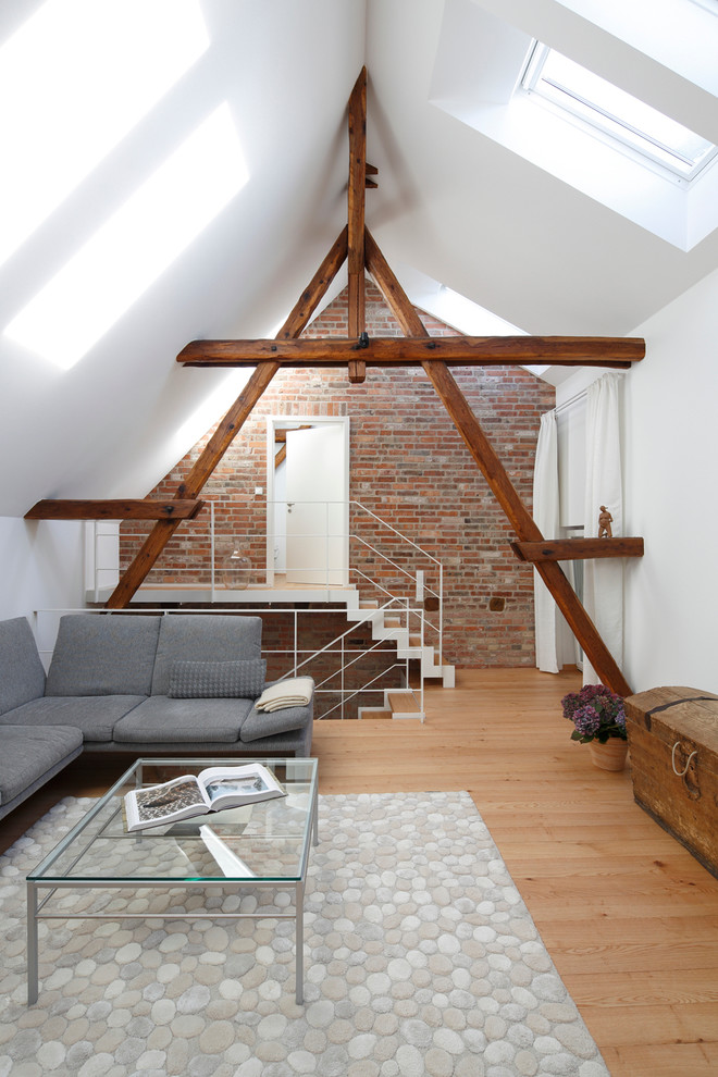 Offenes, Mittelgroßes Modernes Wohnzimmer mit hellem Holzboden, weißer Wandfarbe und Steinwänden in Hannover