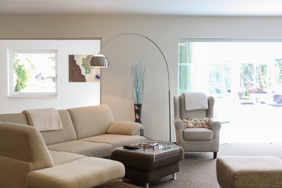 Imagen de sala de estar con biblioteca abierta contemporánea extra grande con paredes blancas, moqueta y televisor independiente