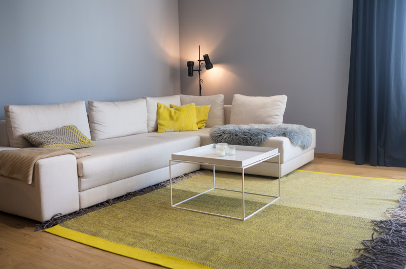 Idee per un soggiorno scandinavo di medie dimensioni e aperto con pareti grigie, parquet chiaro e TV a parete