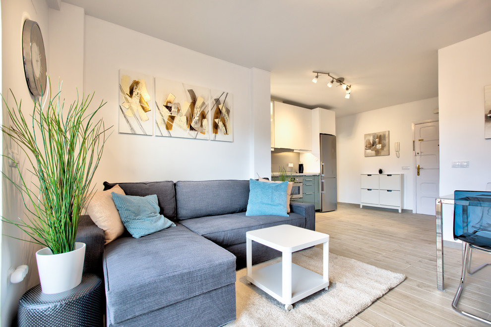 Immagine di un soggiorno design di medie dimensioni e aperto con pareti bianche, pavimento con piastrelle in ceramica, nessun camino, TV autoportante e pavimento beige