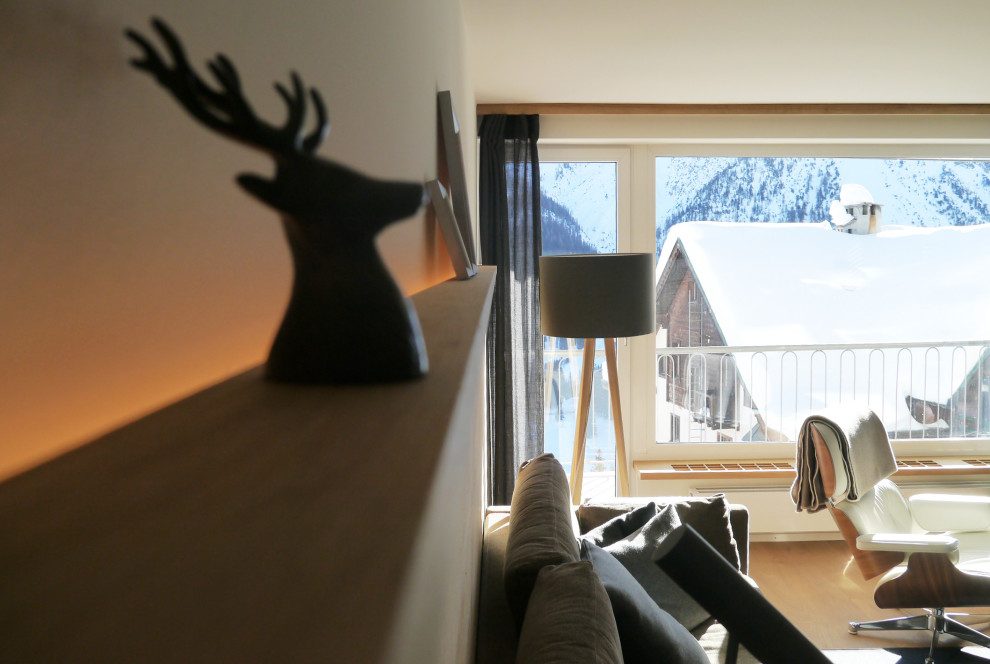 На фото: гостиная комната в стиле кантри с белыми стенами, ковровым покрытием и коричневым полом