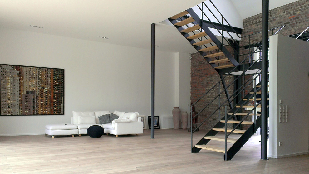 Geräumiges Modernes Wohnzimmer ohne Kamin mit weißer Wandfarbe und hellem Holzboden in Köln