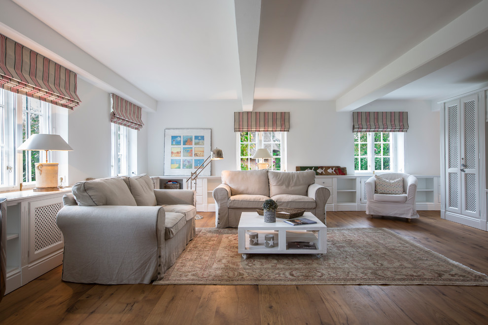 Großes Landhaus Wohnzimmer mit weißer Wandfarbe und braunem Holzboden in Sonstige
