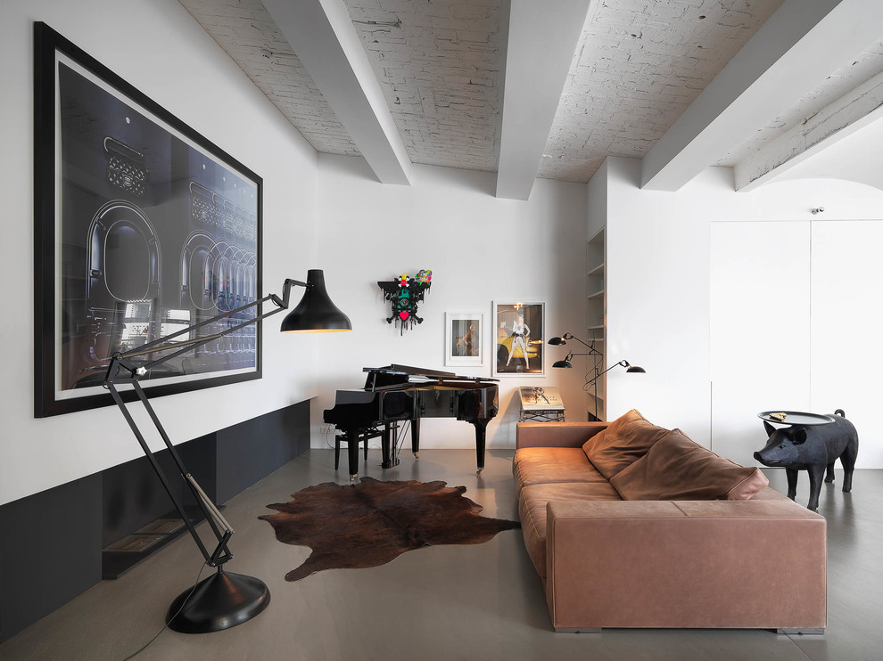 Стильный дизайн: гостиная комната среднего размера в современном стиле с музыкальной комнатой, белыми стенами, бетонным полом и коричневым диваном без телевизора - последний тренд