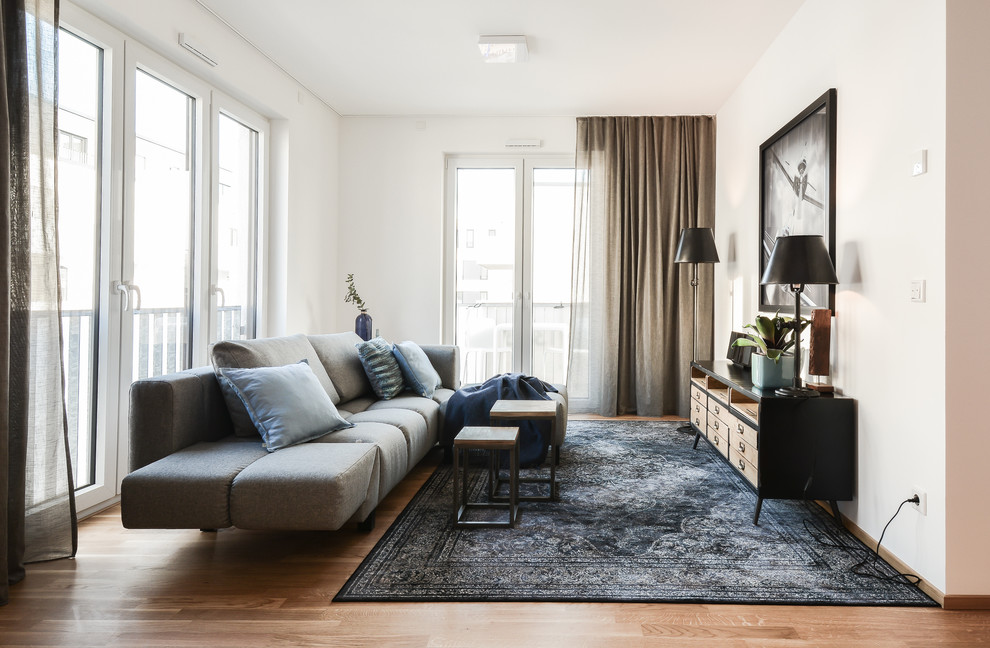 Foto di un soggiorno design aperto e di medie dimensioni con pareti bianche, pavimento in legno massello medio e nessun camino
