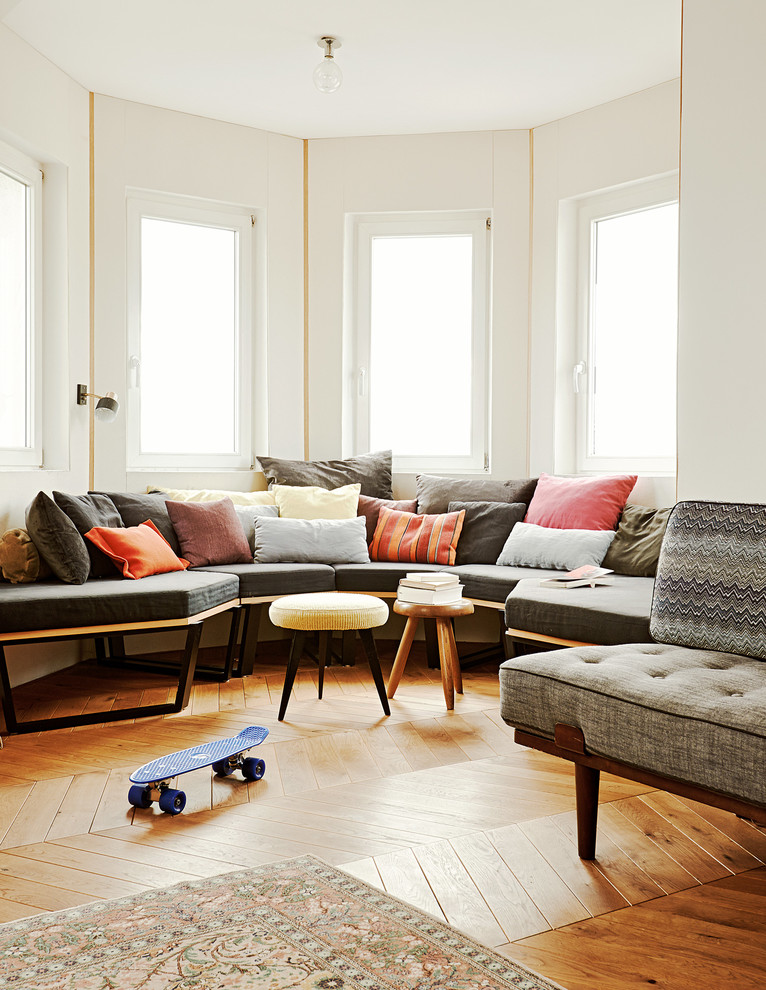 Diseño de sala de estar cerrada contemporánea con paredes blancas y suelo de madera en tonos medios